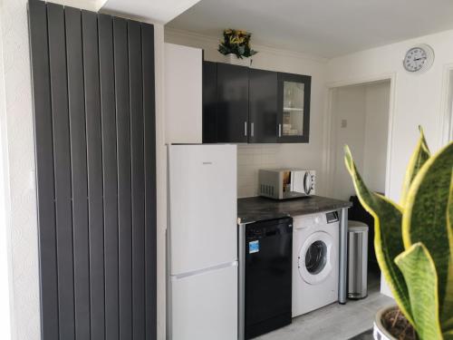 a kitchen with a refrigerator and a washing machine at Benjamin Gardens Holiday Home in Great Driffield
