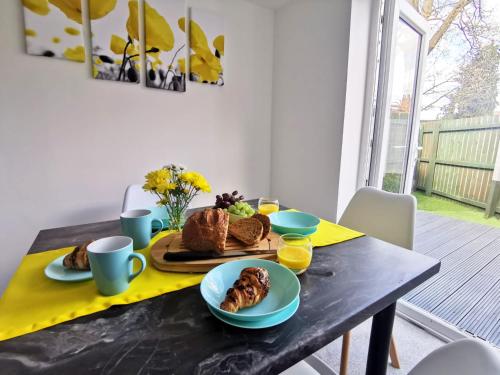 a table with a plate of pastries on it at Benjamin Gardens Holiday Home in Great Driffield