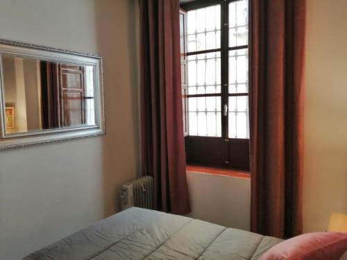 1 dormitorio con ventana, cama y espejo en Casa Epi - Encantador apartamento en el centro de Granada - Barrio Realejo, en Granada