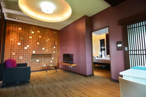 a living room with purple walls and a television at Burapa Boutique in Chiang Mai