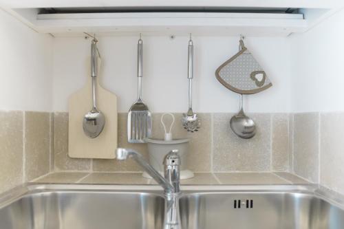 a kitchen with utensils hanging above a sink at La Casetta di Chloè in Ostuni