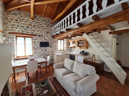 a living room with a white couch and a kitchen at Amanita in Tsagarada