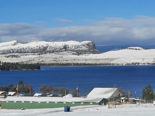 a snow covered mountain with a building and a lake at Lakeviewlanding in Big Arm