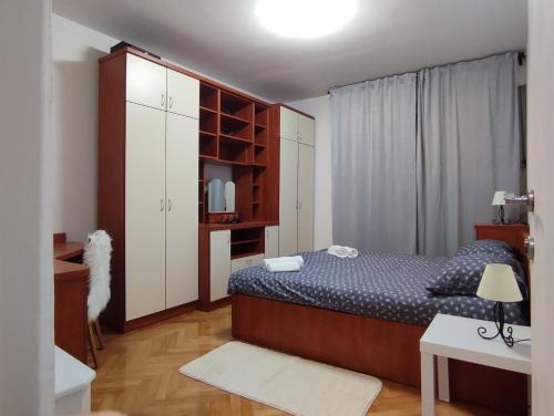 a bedroom with a bed and white cabinets and a desk at Apartman Ivan in Kaštela