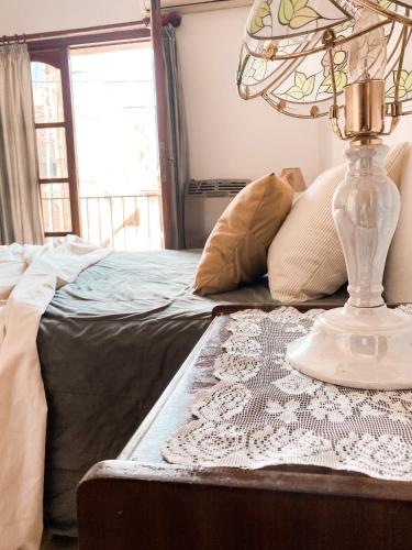 a lamp on a table next to a bed at Casa Moreno in Belén de Escobar