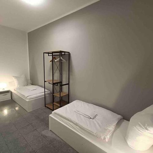 Cette chambre blanche comprend un lit et une étagère. dans l'établissement City-Apartment Sorgenfrei, à Berlin