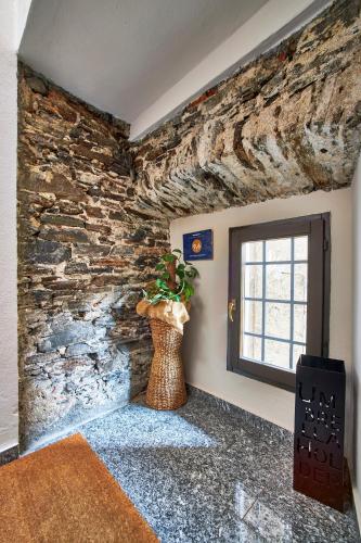 a room with a stone wall and a vase with a plant at Bella Omegna Apartments in Omegna