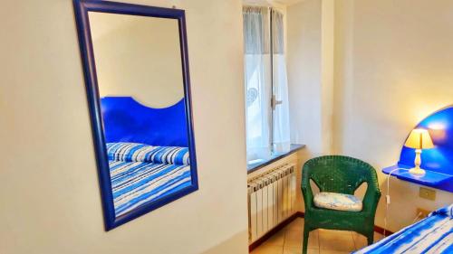 a mirror in a bedroom with a chair and a bed at Good vibes penthouse Ca Lidia 5terreparco in Riomaggiore