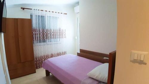 a small bedroom with a bed and a shower at Giorgio Gest House in Përmet