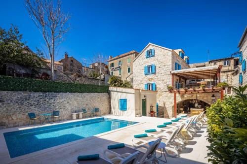 een zwembad met ligstoelen naast een gebouw bij Hotel Agava Split in Split