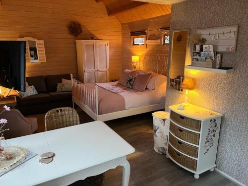 B&B Het Smitshoekje في باريندريخت: غرفة نوم صغيرة مع سرير وغرفة معيشة