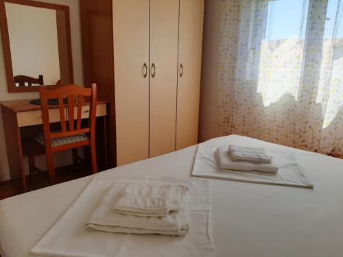 einem weißen Tisch mit zwei Handtüchern darüber in der Unterkunft Apartmani Leon in Šimuni