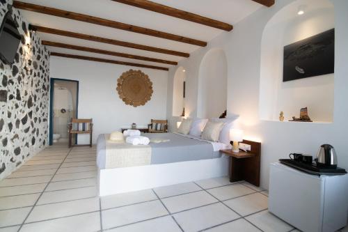 a bedroom with a bed in a room with white walls at DELION VIEW HOTEL in Fira