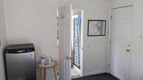 a hallway with a white door and a small table at Apple Place Room #1 in Miramonte
