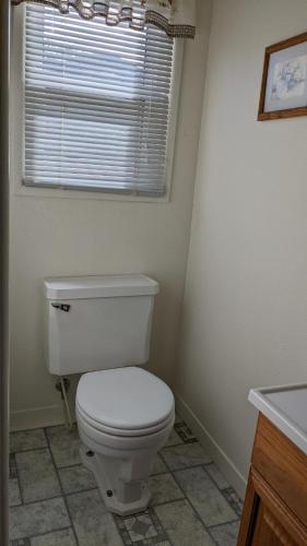 a bathroom with a white toilet and a window at Apple Place Room #1 in Miramonte