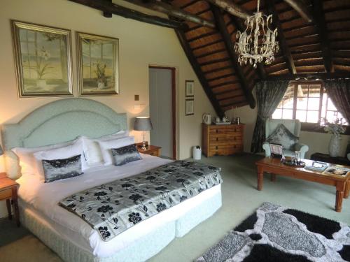 Un dormitorio con una cama grande y una lámpara de araña. en Warrens Guest House, en Hillcrest