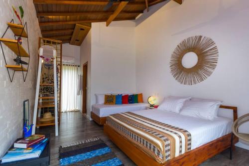 a bedroom with two beds and a mirror on the wall at Canto do Ilé Dive & Lodge in Paraty