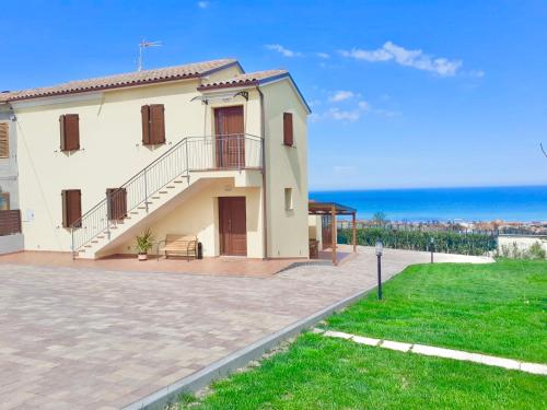 Cette grande maison blanche dispose d'un balcon et offre une vue sur l'océan. dans l'établissement Casa Vacanze con Vista Mare e Giardino - Amanecer, à Marzocca di Senigallia