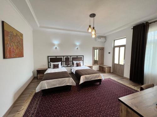 1 dormitorio con 2 camas y alfombra roja en The Loft Guest House en Samarcanda