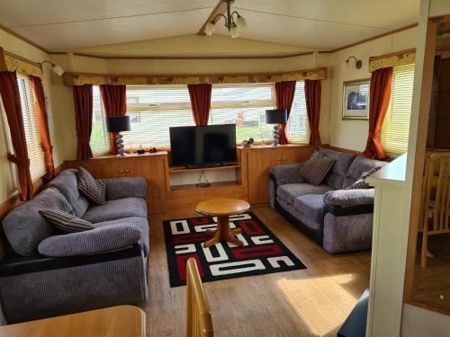 a living room with two couches and a tv at 6 Berth central heated on Golden Sands Vintage in Ingoldmells