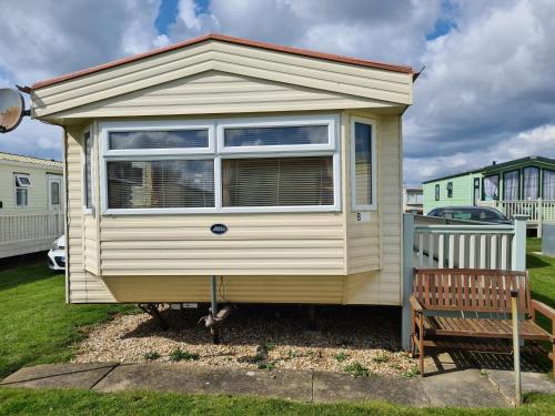 a tiny house in a yard with a bench at 6 Berth central heated on Golden Sands Vintage in Ingoldmells