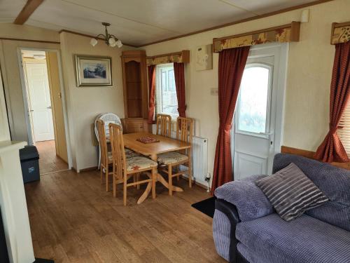 a living room with a table and a couch at 6 Berth central heated on Golden Sands Vintage in Ingoldmells