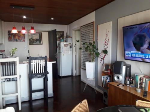 ein Wohnzimmer mit einem Kühlschrank und einem TV in der Unterkunft Tu lugar Departamento 2 ambientes Hindu Club Don Torcuato in Don Torcuato