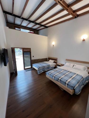 Duas camas num quarto com pisos em madeira em Camellón de la Ferrería em Pacho