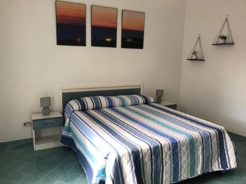 a bedroom with a bed with a striped blanket at Casetta Forio in Forio d'Ischia