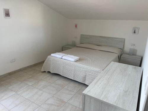 a bedroom with a bed with two towels on it at Oceania apartments in Grosseto