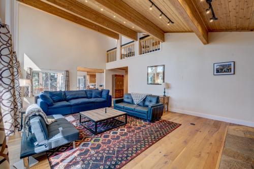 a living room with blue couches and a rug at Mountain & Lake-View Delight in Truckee