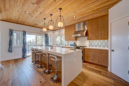 a kitchen with wooden ceilings and a large island with bar stools at Mountain & Lake-View Delight in Truckee
