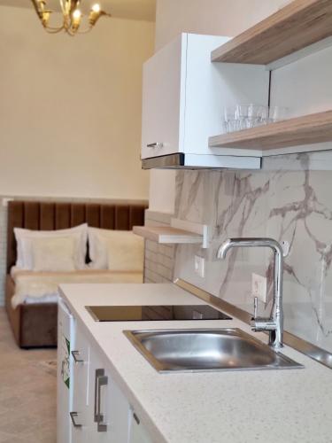 a kitchen with a sink and a couch in a room at Green Villa in Vlorë