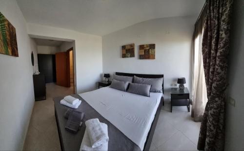 a bedroom with a large white bed and a window at Stathi's House in Megali Ammos