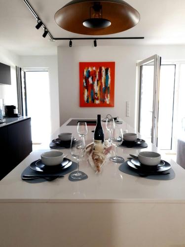 a table with wine glasses and plates on top of it at Strassen - 2 bed designer flat in Strassen