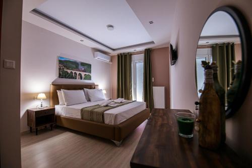 a bedroom with a bed and a table with a mirror at Helena's apartment two in Volos