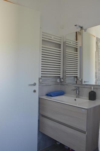 a bathroom with a sink and a mirror at Villa La Parisienne in Diano Borello