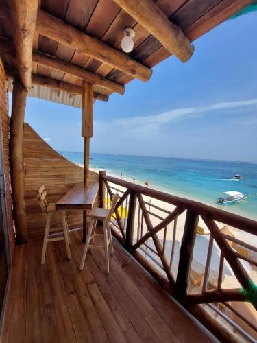 a balcony with a table and chairs on the beach at Hotel Calamari Baru in Playa Blanca