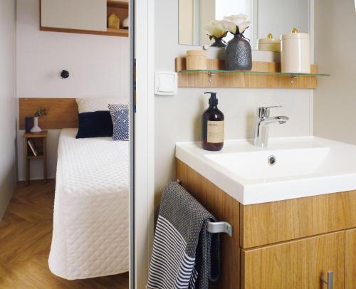 a bathroom with a sink and a mirror at Superbe mobile-home 6 personnes - Camping 4 étoiles in Saint-Jean-de-Monts