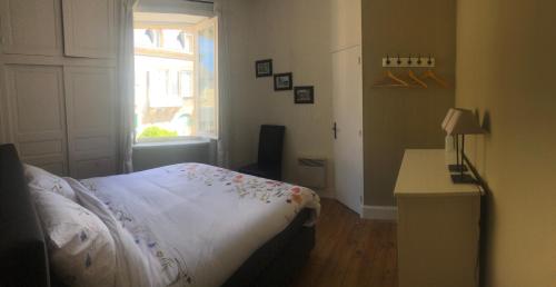 a bedroom with a bed and a desk and a window at Fleur d’Iris in Perpezac-le-Blanc