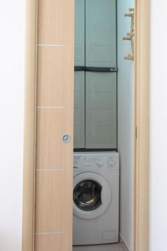 a washer and dryer in a laundry room with a door at La Necussella in Anacapri