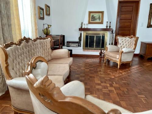 a living room with couches and chairs and a fireplace at Casa Às Oito in Angra do Heroísmo