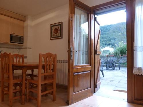 Zimmer mit einem Tisch und einer Glastür in der Unterkunft La Abadía de Fragen-Ordesa in Torla-Ordesa