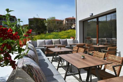 eine Gruppe von Tischen und Stühlen auf einer Terrasse in der Unterkunft IADES suites in Afytos