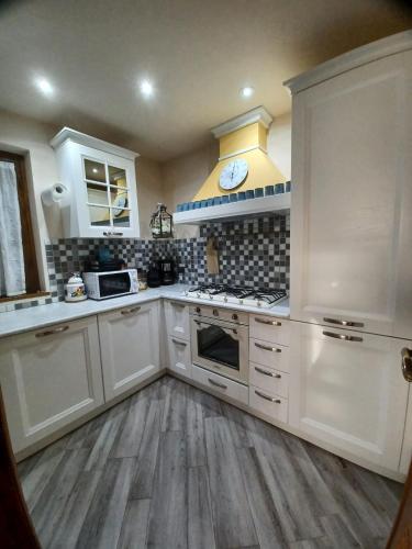 a kitchen with white cabinets and a stove top oven at Villa Daniela in Camaiore
