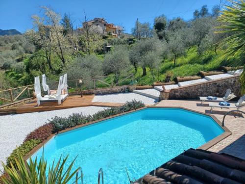 a swimming pool in a yard with chairs and a house at Villa Daniela in Camaiore