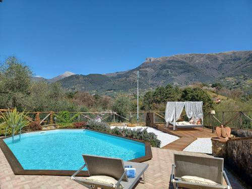 a swimming pool with two chairs and a table at Villa Daniela in Camaiore