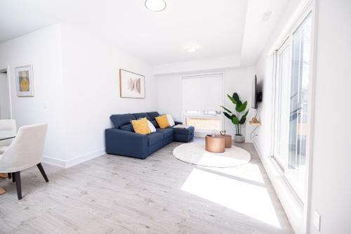 a living room with a blue couch and a table at Luxury & Comfy Apartment, Mins Drive To All Niagara Falls Attraction in Niagara Falls