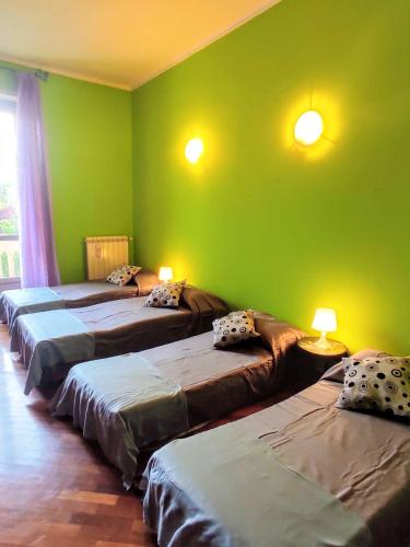 a room with four beds in a room with green walls at Rainbow house Lingotto Inalpi in Turin