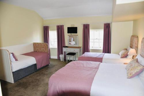 a hotel room with two beds and a desk at Befani's Mediterranean Restaurant & Townhouse in Clonmel